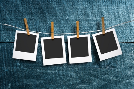 four photo paper attach to rope with clothes pins on wooden backgroundの写真素材