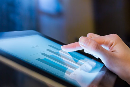 Close-up of female hands touching digital tablet with business diagram