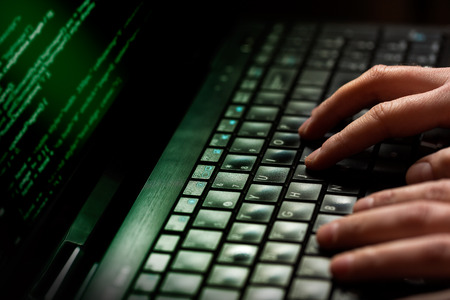 Hacker using laptop  Lots of digits on the computer screen の写真素材