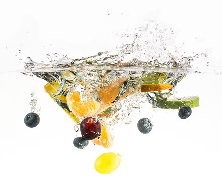Splashing fresh fruit on water on white background の写真素材