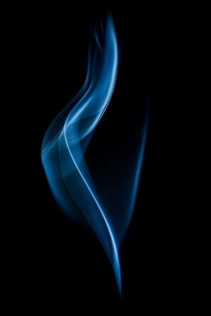 Abstract blue smoke swirls on black background の写真素材