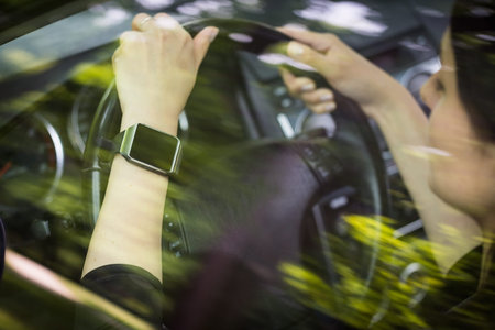 A woman uses smartwatch in the car. Smart watch concept.
