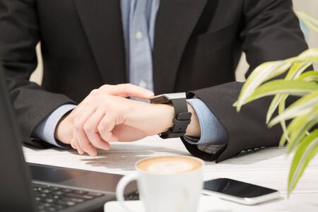 Businessman uses smart watch and phone. Smartwatch concept.の写真素材