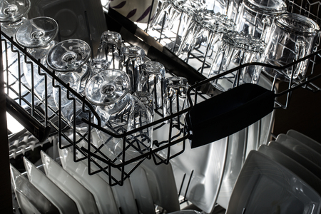 Open dishwasher with clean utensils in it.の写真素材