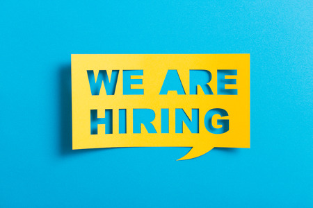 Bubble speech with cut out phrase "we are hiring"  in the paper.の写真素材
