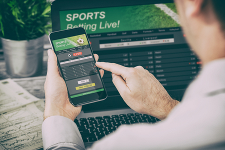 betting bet sport phone gamble laptop over shoulder soccer live home website concept - stock imageの写真素材