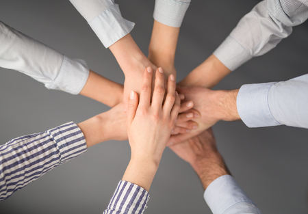 Business people hands stacked in a pile. A symbol of teamwork and trust.の写真素材