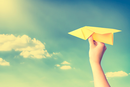 paper travel sky plane child flying yellow fun human leisure kid throw view throwing handmade freedom object up air airline joy concept - stock imageの写真素材