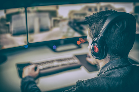 A professional computer player plays on a computer using two monitors.