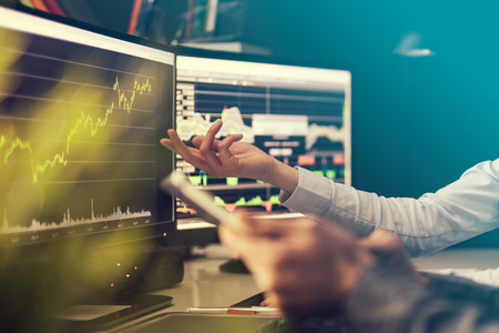 Analyzing data, graphs and reports for investment purposes. Creative teamwork traders.の写真素材