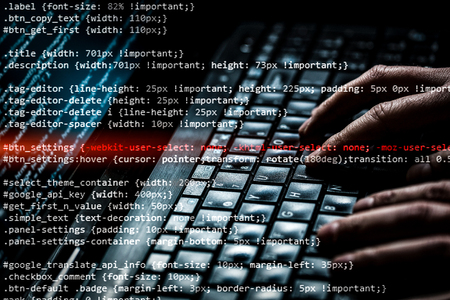 Hacker using laptop. Lots of digits on the computer screen.の写真素材