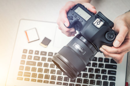 Modern digital DSLR camera and computer workstation. Photography and videography concept.