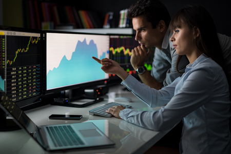 Analyzing data, graphs and reports for investment purposes. Creative teamwork traders.の写真素材