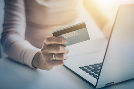 Hands holding credit card and using laptop. Online payment and shopping concepts.の写真素材