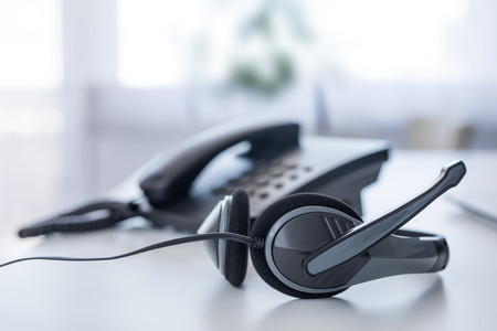 Communication support, call center and customer service help desk. VOIP headset on laptop computer keyboard.の写真素材