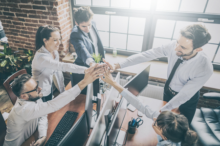 Business people happy showing team work and giving five in office. Teamwork concepts.の写真素材