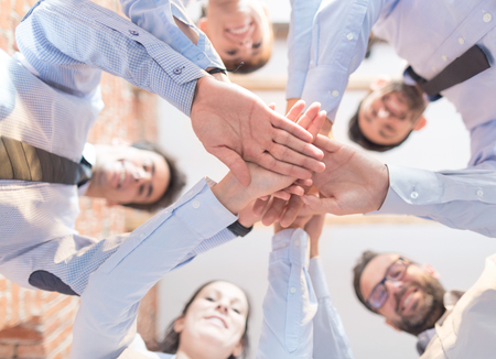 Close up top view of young business people putting their hands together. Stack of hands. Unity and teamwork concept.の写真素材