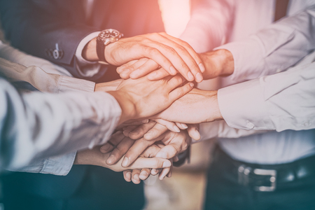 Close up top view of young business people putting their hands together. Stack of hands. Unity and teamwork concept.