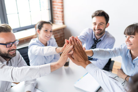 Business people happy showing team work and giving five in office. Teamwork concepts.