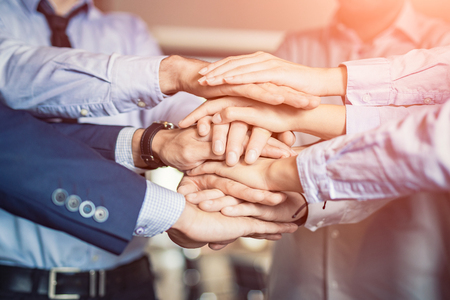 Close up top view of young business people putting their hands together. Stack of hands. Unity and teamwork concept.の写真素材