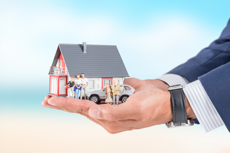 Insurance house, car and family health live concept. The insurance agent presents the toys that symbolize the coverage.の写真素材