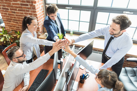 Business people happy showing team work and giving five in office. Teamwork concepts.の写真素材