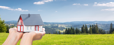 housing house hand real home holding green grass blue sky- stock imageの写真素材