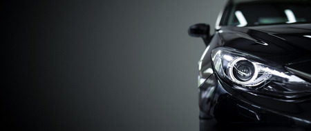 Black modern car closeup on black background.の写真素材