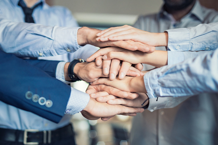 Close up top view of young business people putting their hands together. Stack of hands. Unity and teamwork concept.の写真素材