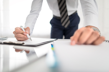 Business man signing contract document on office desk, making a deal.の写真素材