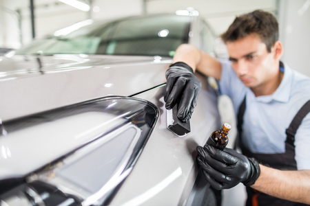 Car detailing - Man applies nano protective coating to the car. Selective focus.の写真素材