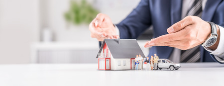 Insurance house, car and family health live concept. The insurance agent presents the toys that symbolize the coverage.の写真素材