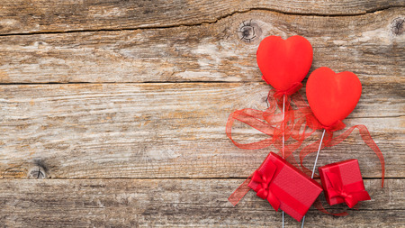Valentines Day background. Two red hearts with a bow on a wooden background.の写真素材