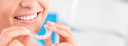 Woman wearing orthodontic silicone trainer. Invisible braces aligner. Mobile orthodontic appliance for dental correction.の写真素材