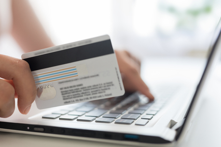 Hands holding credit card and using laptop. Online payment and shopping concepts.の写真素材