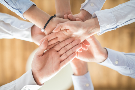 Close up top view of young business people putting their hands together. Stack of hands. Unity and teamwork concept.の写真素材