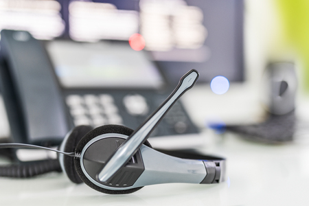 Communication support, call center and customer service help desk. VOIP headset on laptop computer keyboard.の写真素材