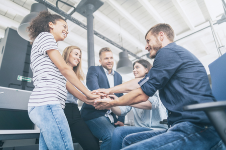 Close up view of young business people putting their hands together. Stack of hands. Unity and teamwork concept.の写真素材