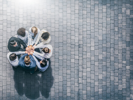 Close up top view of young business people putting their hands together. Stack of hands. Unity and teamwork concept.の写真素材