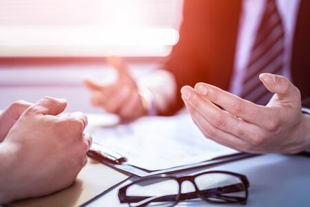 Business people negotiating a contract. Human hands working with documents at desk and signing contract.の写真素材
