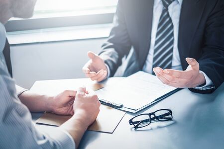 Business people negotiating a contract. Human hands working with documents at desk and signing contract.の写真素材
