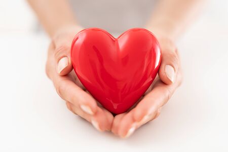 The woman is holding a red heart. Concept for charity, health insurance, love, international cardiology day.の写真素材
