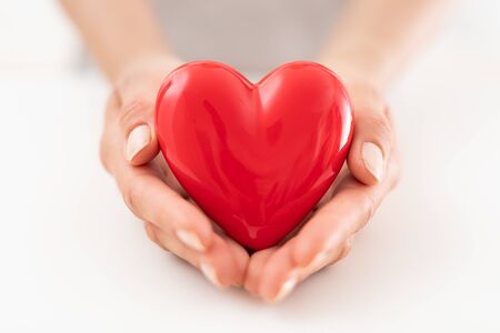 The woman is holding a red heart. Concept for charity, health insurance, love, international cardiology day.