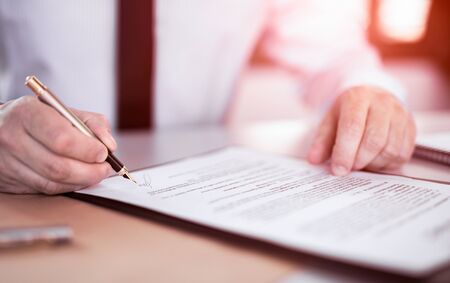 Business man signing contract document on office desk, making a deal.の写真素材
