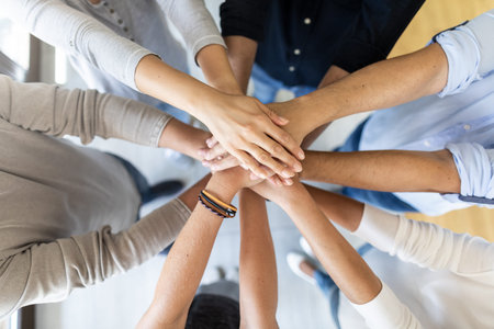 Close up view of young business people putting their hands together. Stack of hands. Unity and teamwork concept.の写真素材