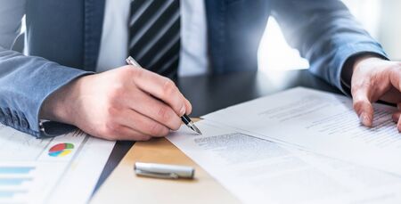 Business man signing contract document on office desk, making a deal.の写真素材