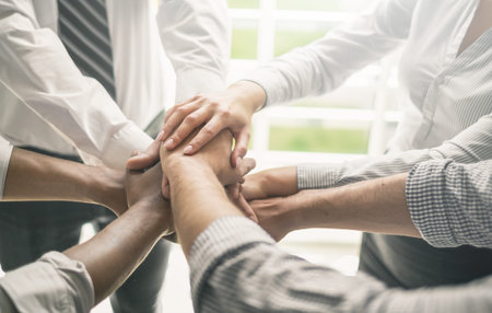 Close up view of young business people putting their hands together. Stack of hands. Unity and...