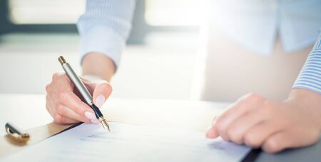 Business woman signing contract document on office desk, making a deal.の写真素材