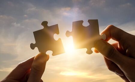 The man holds in his hand a jigsaw puzzle. Business solutions, success and strategy concept.の写真素材