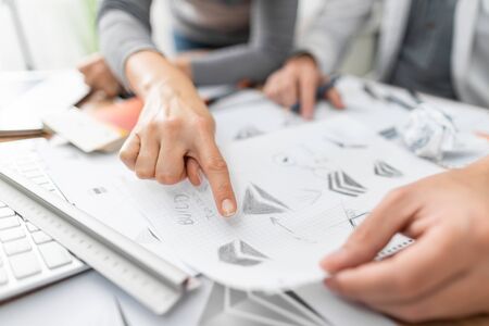 Graphic designer drawing sketches logo design. The concept of a new brand. Professional creative occupation with idea.の写真素材
